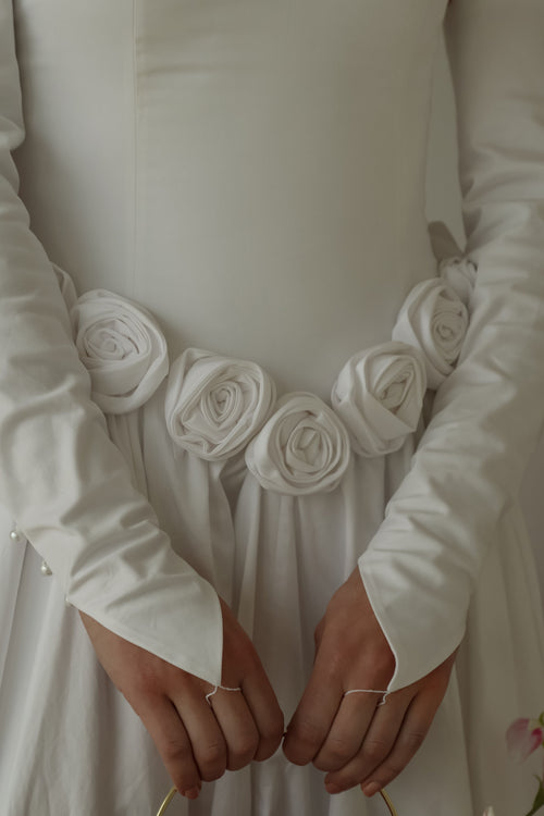 Close up of the fabric rosettes along the basque waistline of the midnight garden gown.