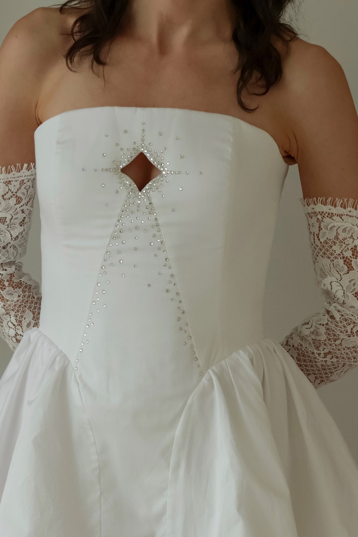 Close-up showing the four point star cutout and crystal embellishment on the structured bodice.