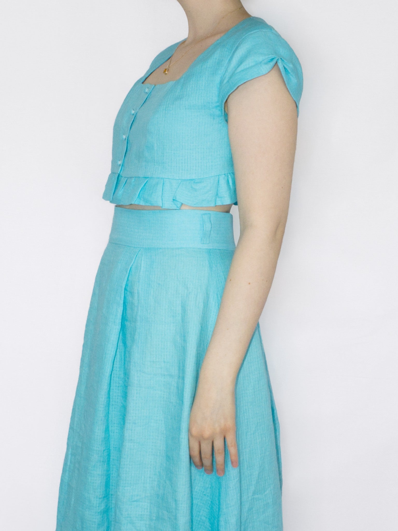 Side view showing the pleated detail on the cap sleeves.