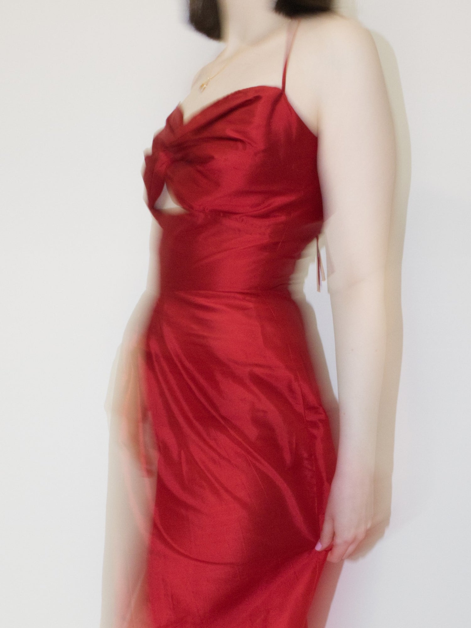The red 'Silk Twist Maxi Dress' with motion blur.